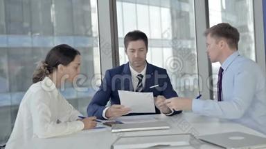 中年商人在会议室与助手会面时阅读文件